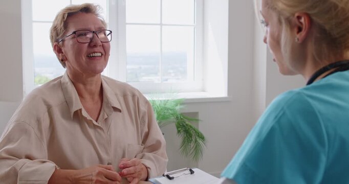 Senior patient in consultation with doctor. In a clinic office, a healthcare professional listens and notes during an appointment, encouraging open discussion. Clear care, support, and advice.