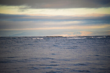 Fototapeta premium Calm sea with distant waves under cloudy sky