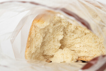 Fresh wheat bread in a clear plastic bag, broken inside the bag