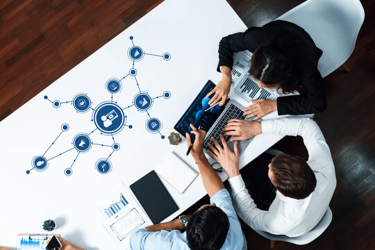 A diverse business team works together on a marketing strategy, utilizing digital tools, data visualization, and collaborative methods in a modern office environment. Amity