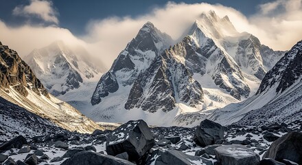 Majestic snowcapped mountains bathed in dramatic sunlight with clouds swirling around the peaks