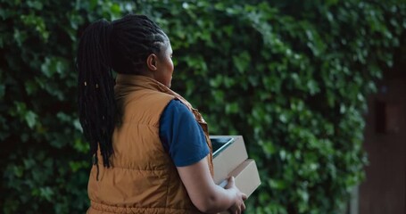 Walking, courier and box with black woman outdoor for shipping, distribution service or ecommerce parcel. Online shopping package, delivery and cargo with person and tablet for supply chain checklist