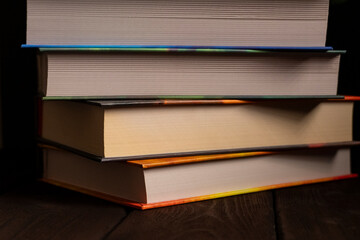 Stack of hardcover books on wooden surface