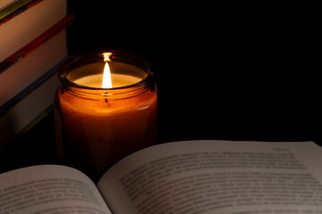 Candlelight and an open book in a cozy dark setting
