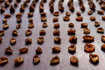 Dried apricots arranged in rows on a baking sheet