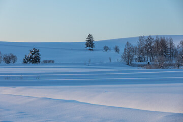 Blue shadows and quiet winter hills before sunrise
