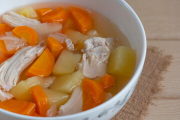 Homemade chicken soup with vegetables in a white bowl