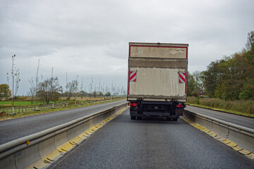 Naklejka premium Large truck on road with low temporary barriers both sides