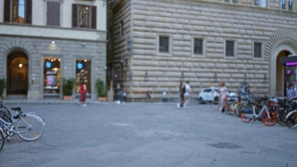 Fototapeta premium Soft blurred city square scene with shallow bokeh and defocused historic stone facade and parked bicycles in background; background copyspace backplate calm.