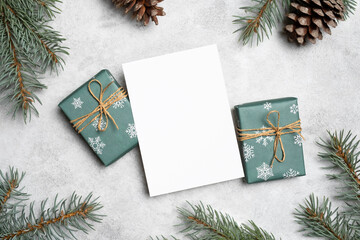 Blank Christmas holidays paper card mockup with decorated gift boxes and pine cones, copy space over white card