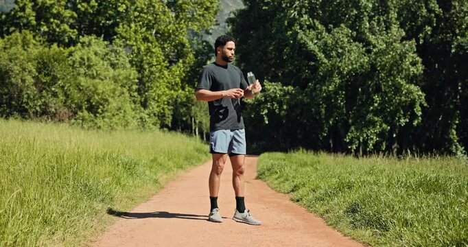 Runner, man or drink water in nature with break for sports hydration, check smart watch or wellness. Person outdoor, beverage or tech for exercise recovery, electrolytes or monitor cardio performance