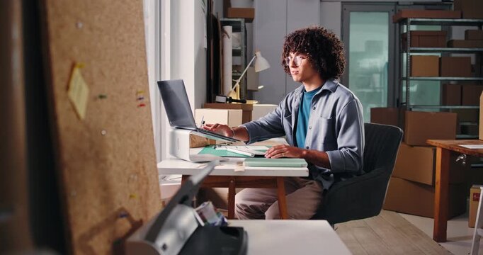 Ecommerce, laptop and writing with man in warehouse for shipping, distribution or inventory manager. Delivery, supply chain or quality control with person in small business for online supplier email