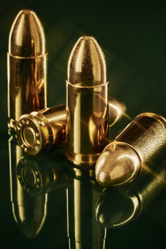 9MM Gold Copper Bullets Macro Still Life Shot on Green Glass with Reflections 