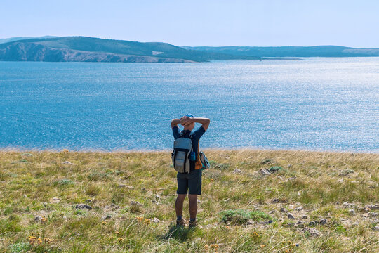 Young male hiker enjoying scenic coastal view on a sunny day. Hiking trail near Baška, Krk Island, Croatia - Powered by Adobe