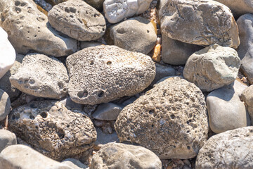 Sunlit weathered rocks with unique textures on a beach
