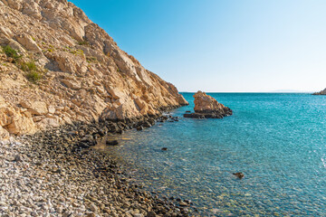 Rocky coastline with clear turquoise waters under bright blue sky