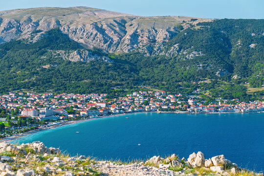 Coastal village with mountain view: scenic seaside landscape and hillside. Baška, Krk island, Croatia