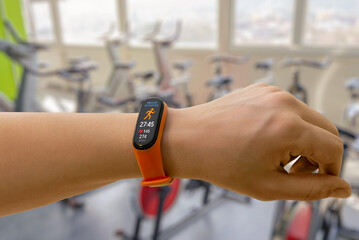 Smart band tracking indoor activity in a modern gym, showing workout duration, heart rate, and calories burned for fitness performance monitoring
