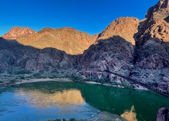 Naklejka premium The Black Bridge on the South Kaibab Trail crosses the Colorado River deep inside the Grand Canyon in morning light.
