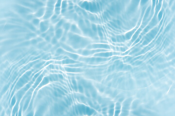 Blue water with ripples on the surface. Defocus blurred transparent blue colored clear calm water surface texture with splashes and bubbles. Water waves with shining pattern texture background.