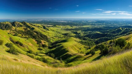 Obraz premium Breathtaking Scenic View of Rolling Green Hills Under Bright Blue Sky with Expansive Horizon and Vibrant Natural Landscape in Daylight