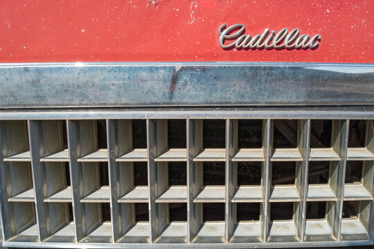 Oregon, USA - September 11, 2025: The logo and a section of the grille on a red 1976 Cadillac