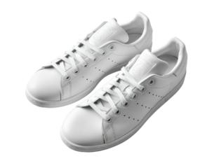 Pair of pristine white leather sneakers, angled, on dark background