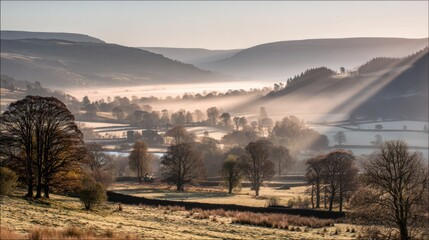 Fototapeta premium Serene Morning Landscape in the Valley with Soft Light Rays Illuminating Trees and Mist over Fields and Hills in Early Sunrise Atmosphere