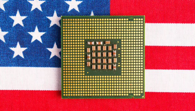 A chip against the backdrop of the US flag. Concepts of a trade war with the Chinese.