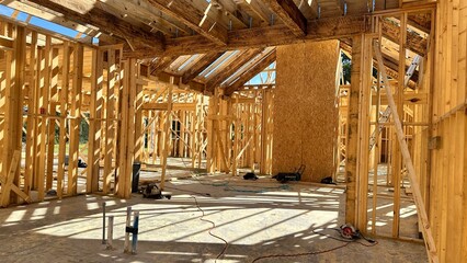 Interior framing of new house with wood studs, beams, and plumbing rough-in