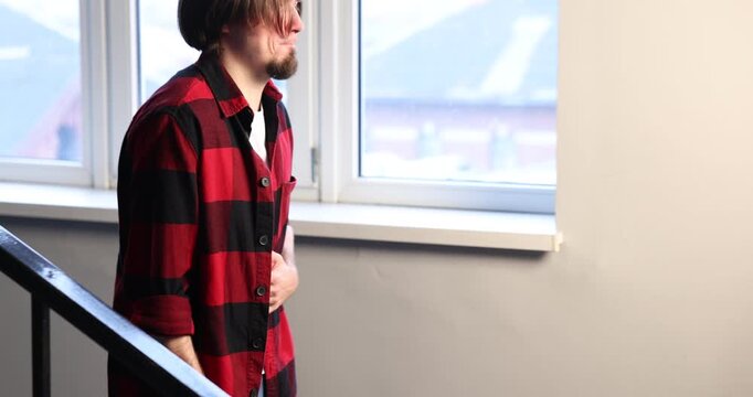 Man suffering from stomach ache and nausea on staircase