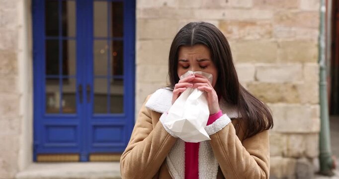Young woman with bag suffering from nausea outdoors