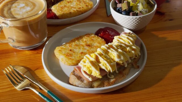 Appetizing Brunch Platter with Sweet French Toast Stacks, Coffee Latte, and Savory Hash Browns on Wooden Table