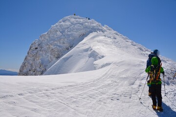 雪の谷川岳の山頂と登山者
