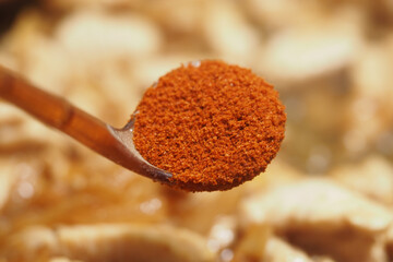 Spicy chili powder being added to a pot of stew
