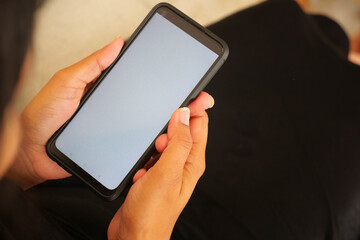 Holding a smartphone in hand while sitting comfortably