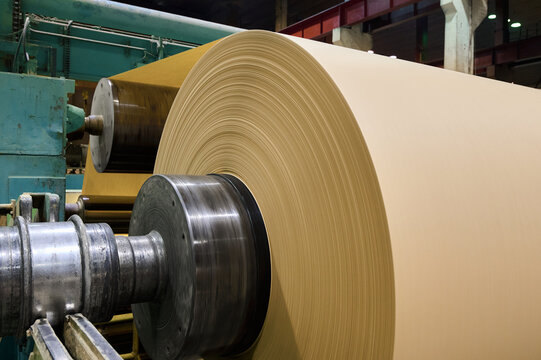 Large roll of brown paper in a paper manufacturing plant during production