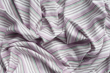 Striped cotton fabric, displaying soft folds and creases.