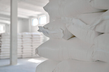 Wheat flour bags arranged in a large warehouse with bright lighting and spacious layout for efficient storage and distribution