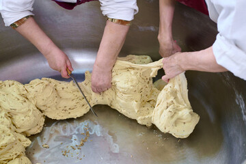 Dough transformation at a bustling bakery during early morning hours with skilled hands working meticulously