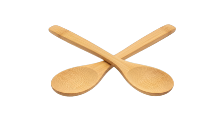 Two natural bamboo wooden spoons crossed on a black background studio shot overhead view of kitchen utensils for cooking and serving food