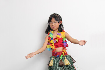 5-year-old Latina girl with brown hair enjoys learning to dance Hawaiian, wearing a colorful skirt and leis, and shows off her moves
