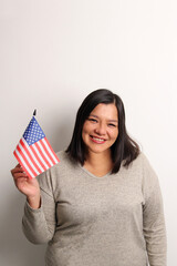 40-year-old Latina woman proudly displays the United States flag as a symbol of migration and freedom