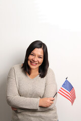 40-year-old Latina woman proudly displays the United States flag as a symbol of migration and freedom