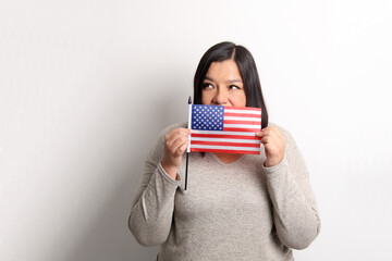 40-year-old Latina woman proudly displays the United States flag as a symbol of migration and freedom