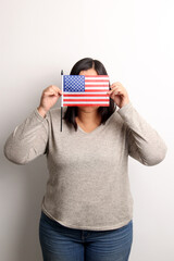 40-year-old Latina woman proudly displays the United States flag as a symbol of migration and freedom