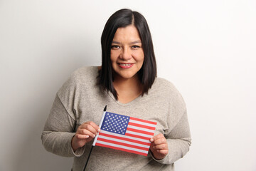 40-year-old Latina woman proudly displays the United States flag as a symbol of migration and freedom