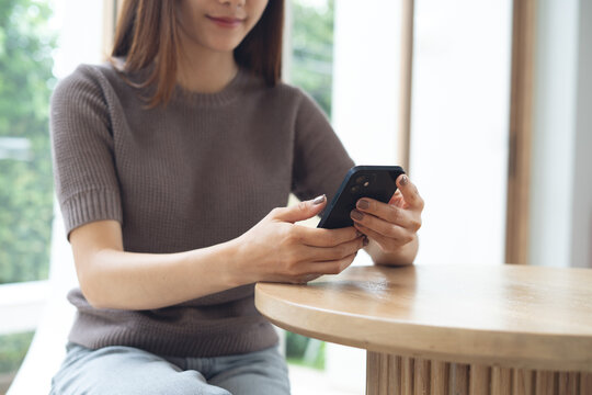 Young asian woman using smartphone in coffee shop. social media network, online messaging and chatting on mobile app, people, lifestyle, closeup