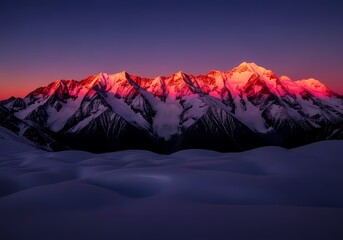 Snow-capped mountain range illuminated by vibrant pink and purple hues during sunrise or sunset