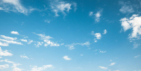 the sky is clear blue with fluffy white clouds, the sky is very bright, and the sun shines.